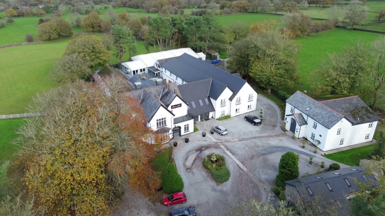 Aerial view of business premises surrounded by green countryside